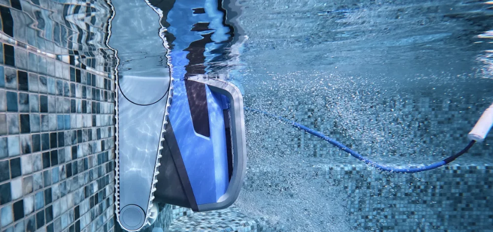 Main débranchant la prise secteur du boîtier d'alimentation Dolphin au bord d'une piscine