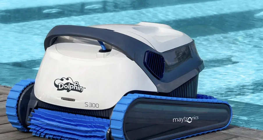 Robot nettoyeur de piscine Dolphin S300 posé au bord d'un bassin avec son boîtier d'alimentation électrique